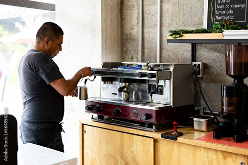 Cafeteria worker preparing coffee based drink with espresso machine photo