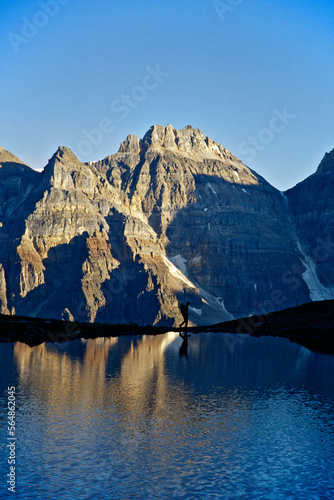 person walking on edge of lake with mountains in backround, BC, Canada photo