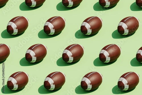 3d Rendering of several oval American football ball on a green. photo
