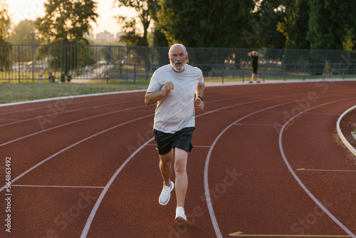 Senior Athlete Jogging On A Running Track photo