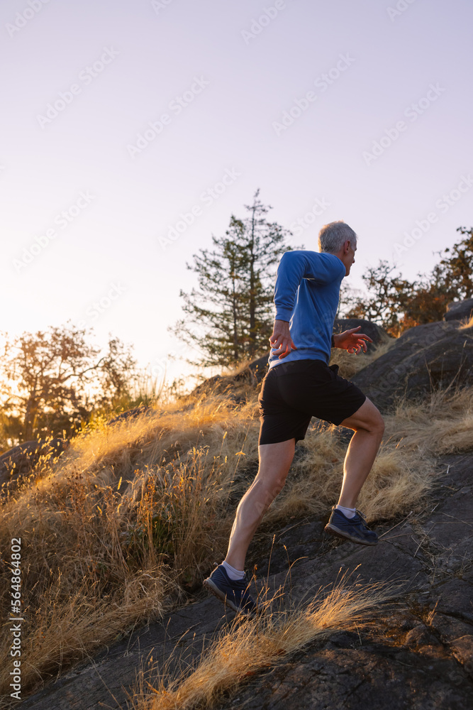 Man running uphill on trail to mountain sunrise. Man running uphill on trail to mountain sunrise.