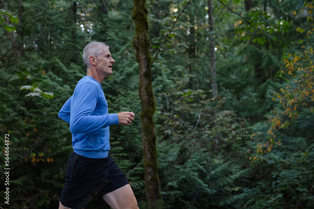 Man training and running on trails in the forest. Man training and running on trails in the forest.