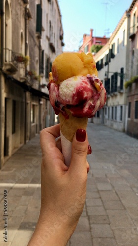 UGC, a hand holding an Italian gelato in the middle of the street photo