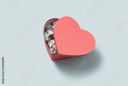 Creasy 100 dollar bills inside heart-shaped box. photo