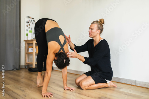 Instructor helping student with exercise technique photo