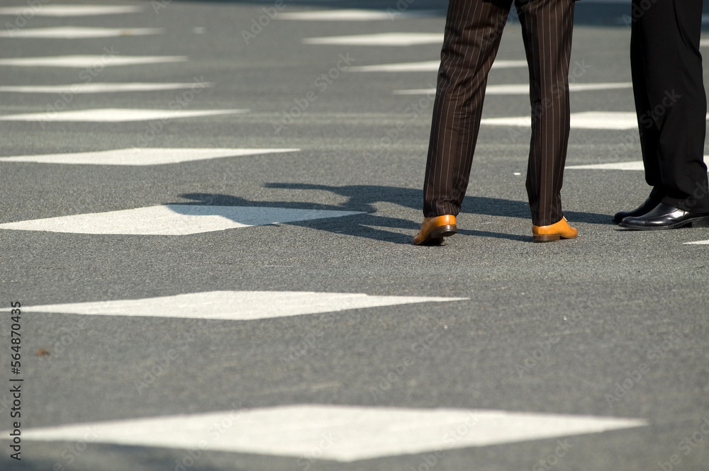 Legs of two people and their shadow on the pavement Legs of two people and their shadow on the pavement