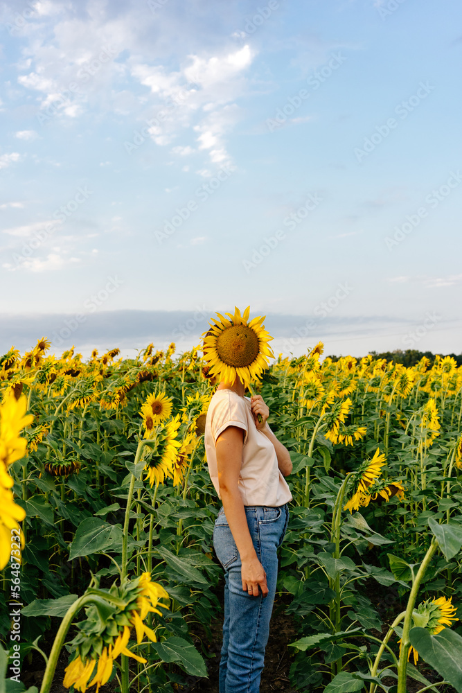 Person covering face with sunflower Person covering face with sunflower