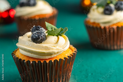 Cupcake with cream, blueberries and edible leaves photo