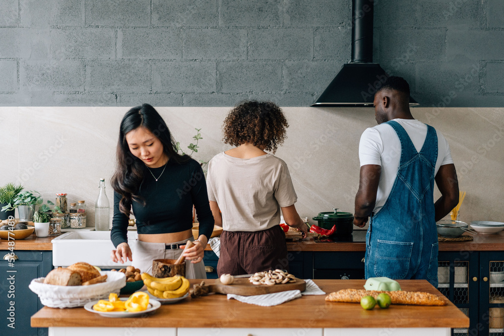 Diverse friends preparing healthy food in kitchen Diverse friends preparing healthy food in kitchen
