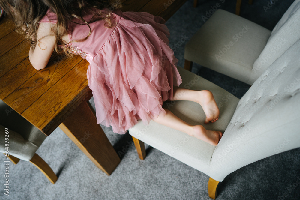 Little girl in pink dress on a chair Stock Photo | Adobe Stock