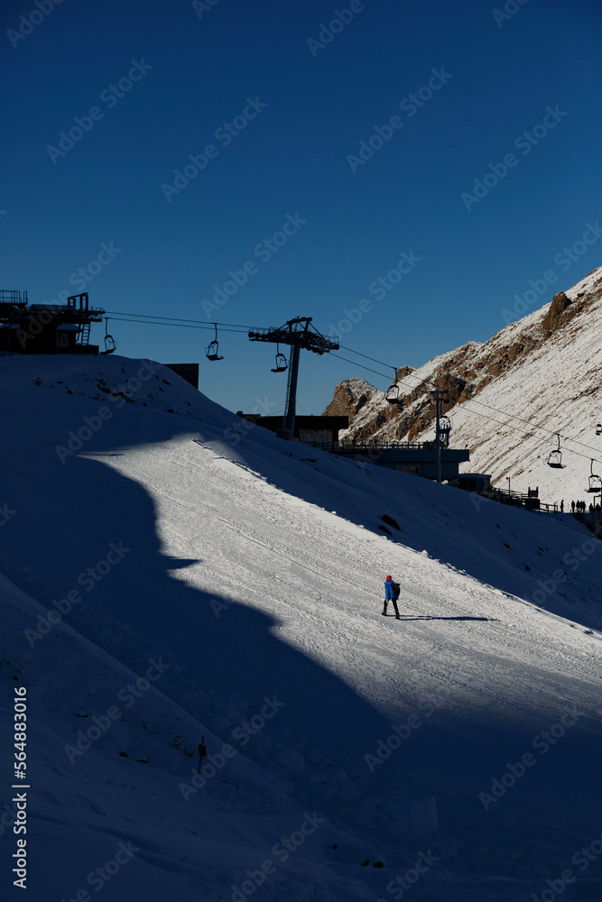 Tourist walking near ropeway on ski resort Tourist walking near ropeway on ski resort