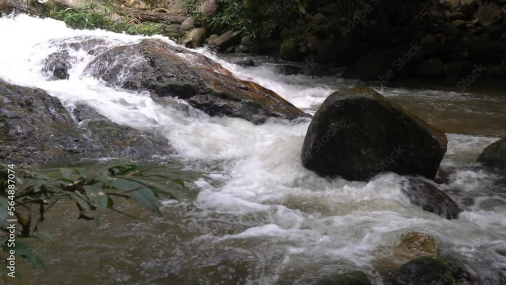 Clear natural mountain stream water flowing over big rocks in the rainforest in spring. Clear natural mountain stream water flowing over big rocks in the rainforest in spring.