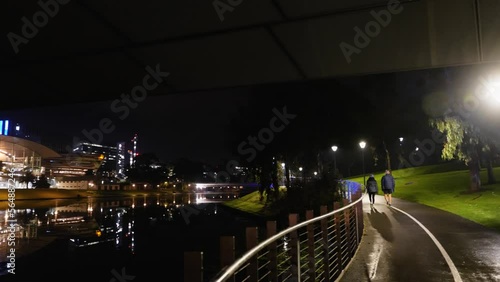 Adelaide Convention Centre in Dark Early Morning with Couple walking on River Torrens  photo