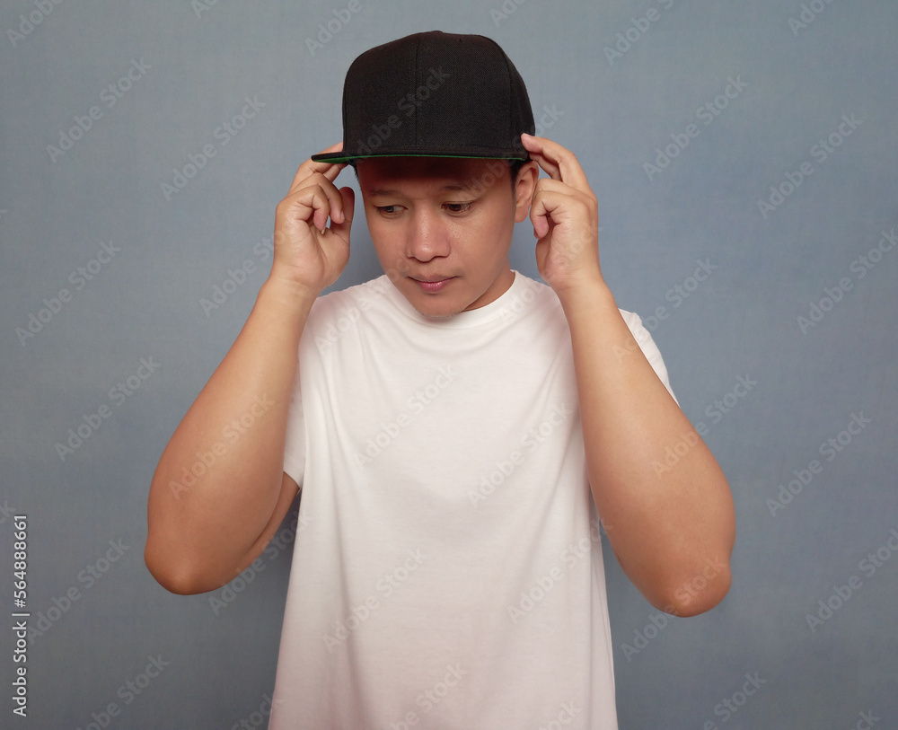 Young man posing wearing white t shirt and black snapback cap Young man posing wearing white t shirt and black snapback cap