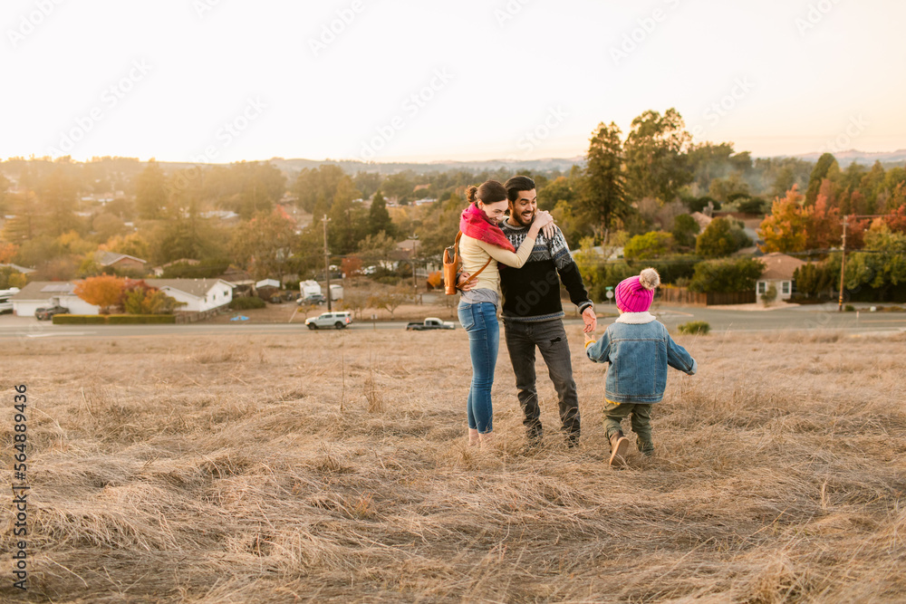 Happy family enjoying by the field in cold season Happy family enjoying by the field in cold season
