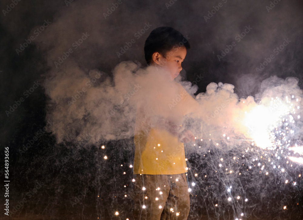 Asian little boy, playing with firework at night in nature outdoors Asian little boy, playing with firework at night in nature outdoors