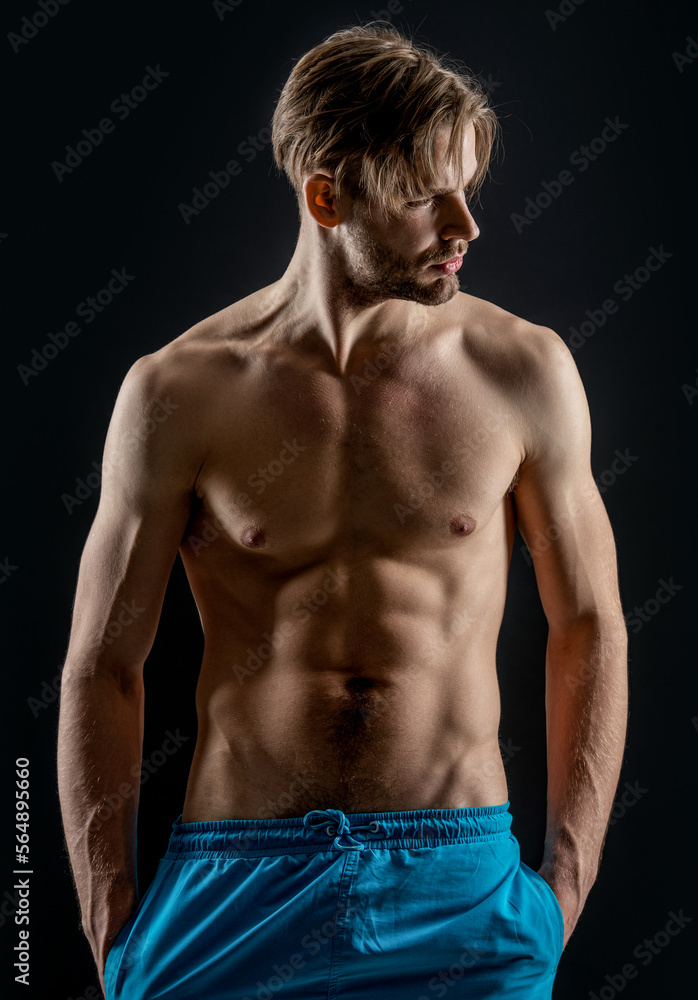 Fototapeta premium muscular macho man with sixpack isolated on black background. man with muscular sixpack
