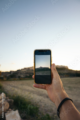 Unrecognizable person taking photos with smartphone of Mdina, Malta photo