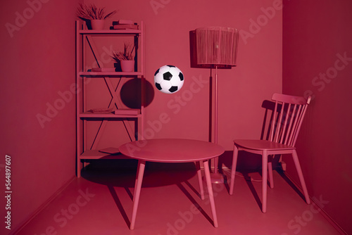 Conceptual still life with a soccer ball in a red monochrome room