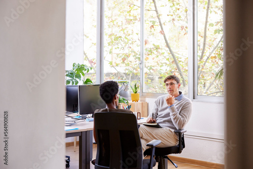 Male manager interviewing black female employee photo