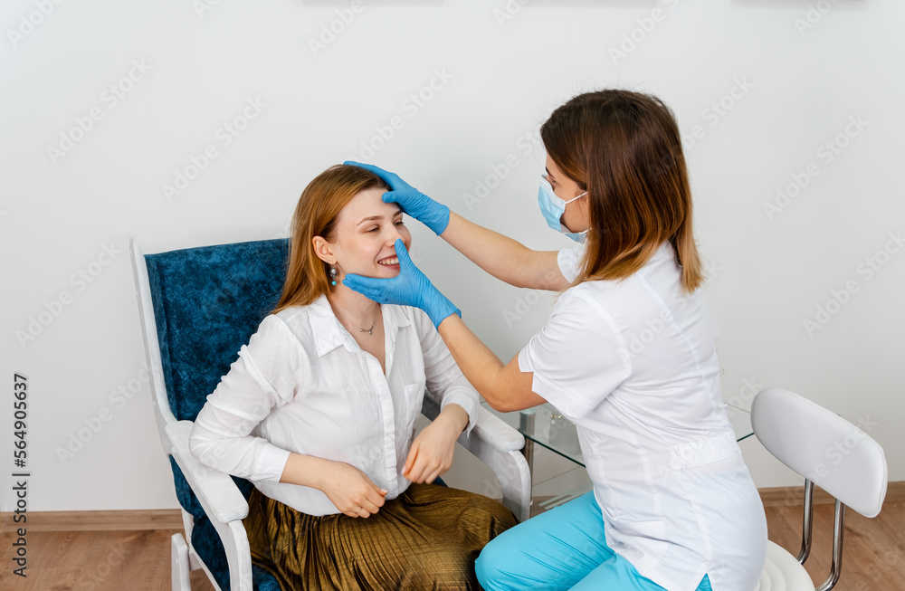 Obraz premium Female beauty doctor talking with patient. Girl tells what she wants change in her face. Independent woman in consultation with a doctor in modern medicine cabinet. Consultation in cosmetology clinic.