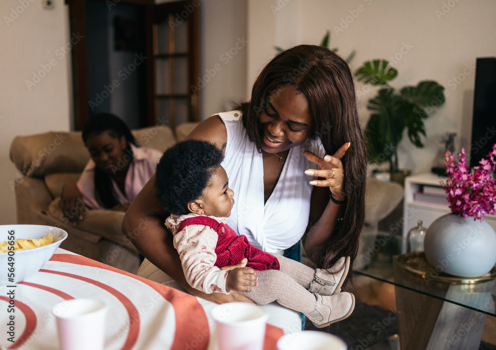 © Pedro Merino/Stocksy - Black baby in her mother's arms at home