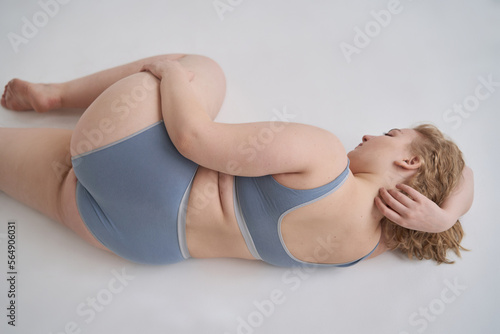 Gorgeous obese woman in underwear lying on floor