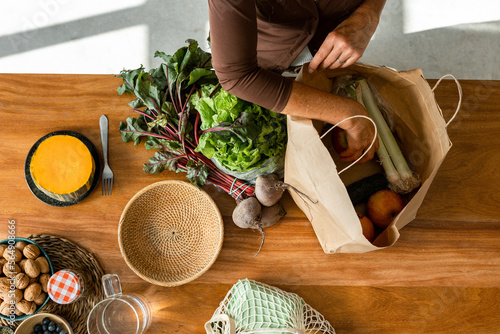 Crop woman unpacking grocery bag