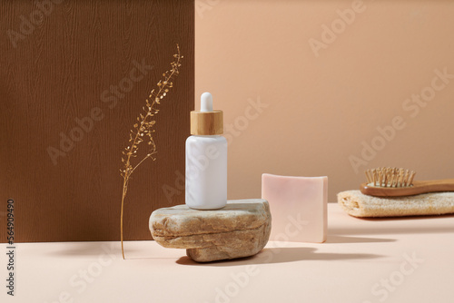 Cosmetic white glass bottle on grange natural stone and wooden