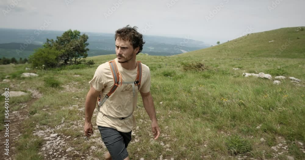 Hiker walking up a hill towards the top of mountain Slavnik, with the view at the Adriatic sea in background. Hiker walking up a hill towards the top of mountain Slavnik, with the view at the Adriatic sea in background.