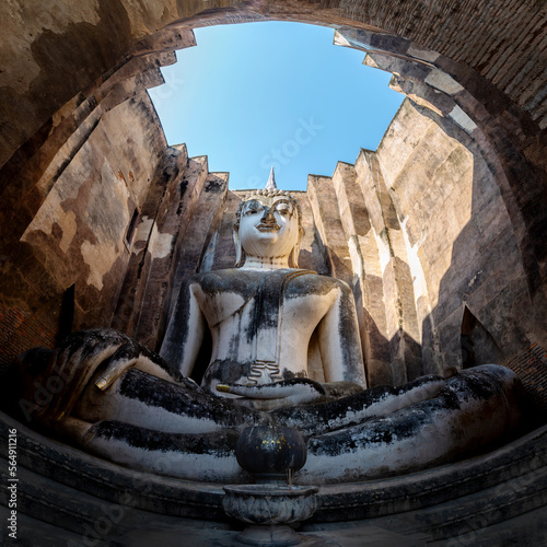 An ancient sitting Bddha statue name Phra Ajana in an abandoned temple against the sky at Wat Srichum famous place at Sukhothai Thailand.