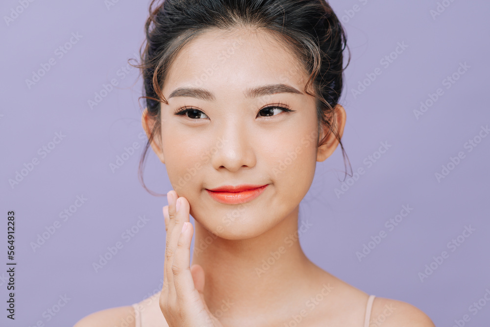 © Marc Tran/Stocksy - Young woman touching cheek and looking at camera © Marc Tran/Stocksy - Young woman touching cheek and looking at camera