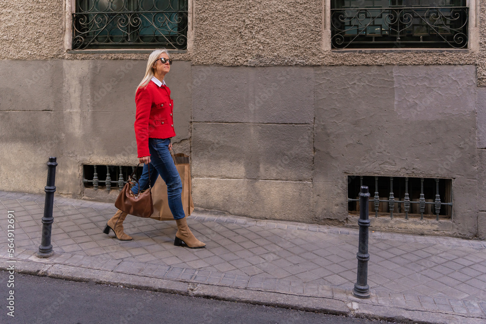 White Hair Woman With Red Jacket Walking On The Street. White Hair Woman With Red Jacket Walking On The Street.