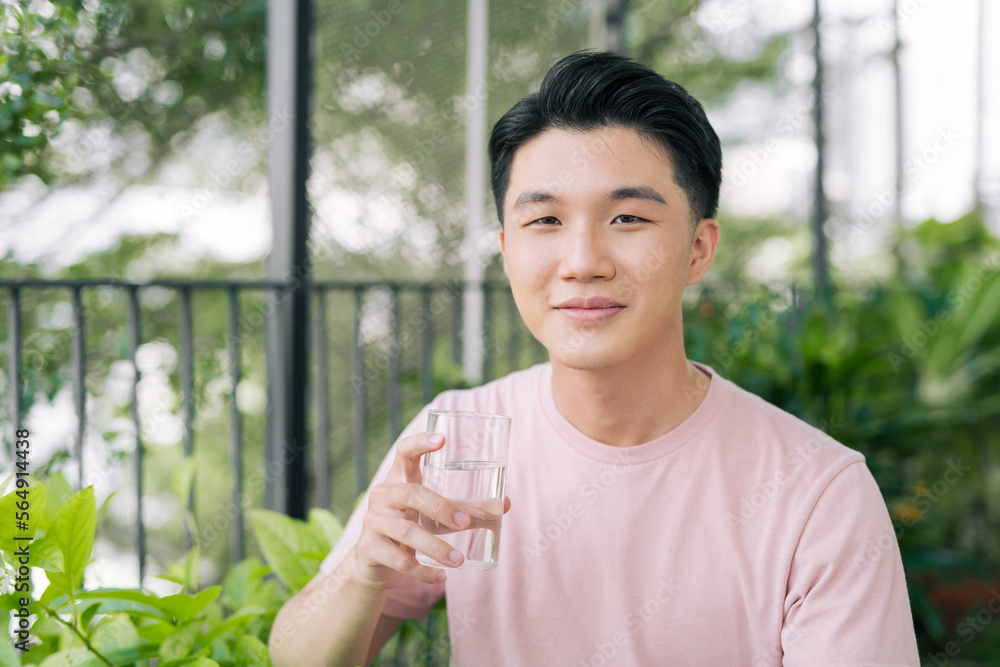 Single man drinking water from a glass at balcony
