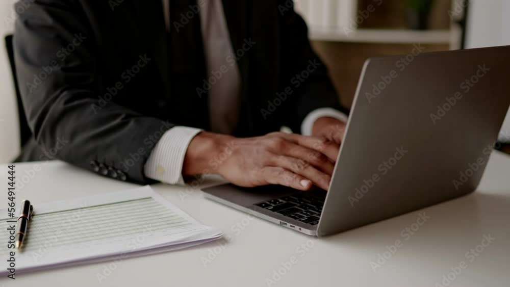 Close up of hands businessman working on laptop and paperwork that show cost planning accounting numbers tables on office space. Close up of hands businessman working on laptop and paperwork that show cost planning accounting numbers tables on office space.