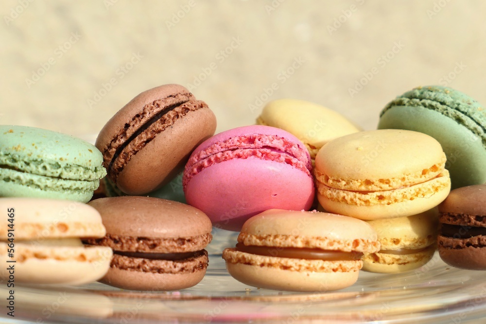 Colorful frensch macarons stacked on a glass plate, close up, light background Colorful frensch macarons stacked on a glass plate, close up, light background