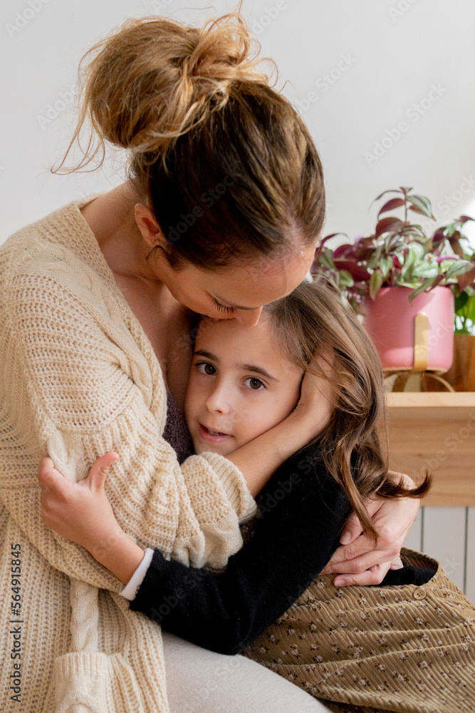mother embracing to her daughter sitting on the floor mother embracing to her daughter sitting on the floor