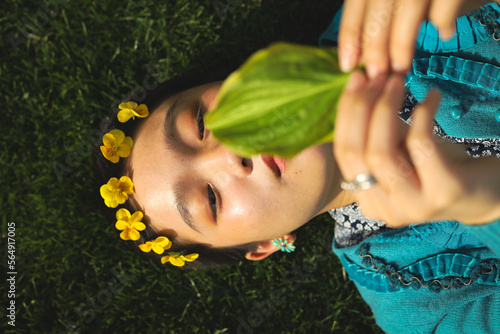Woman with flower crown lying in the grass photo
