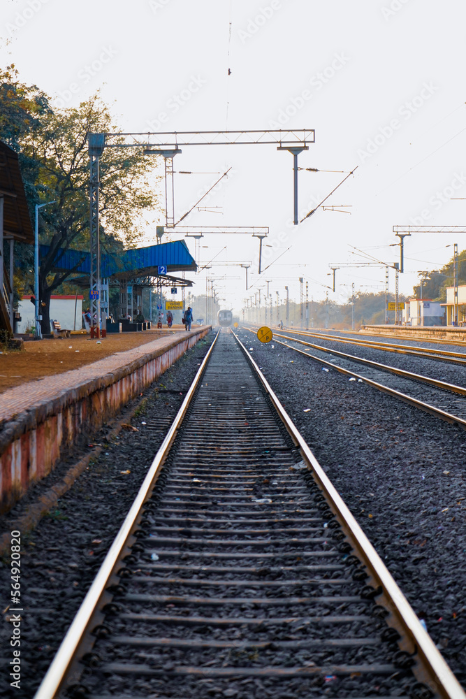 railway platform or station with track, cable line goes above the rail line to pass electricity, Metal railway track in india, metal track for train in india, travel and transportation concept.