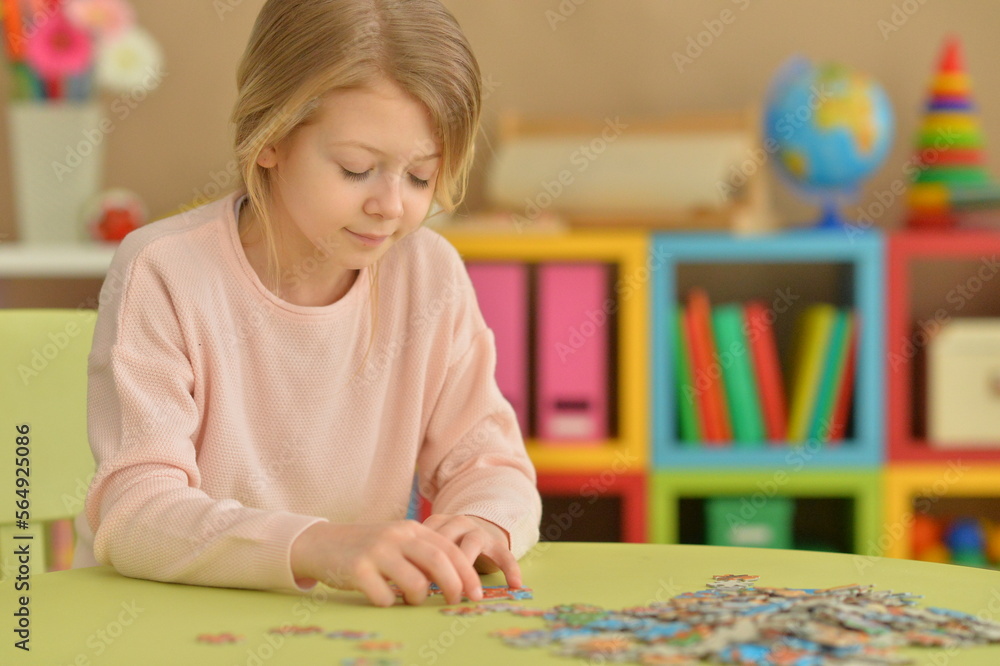 Cute little girl collecting puzzle pieces at home Cute little girl collecting puzzle pieces at home