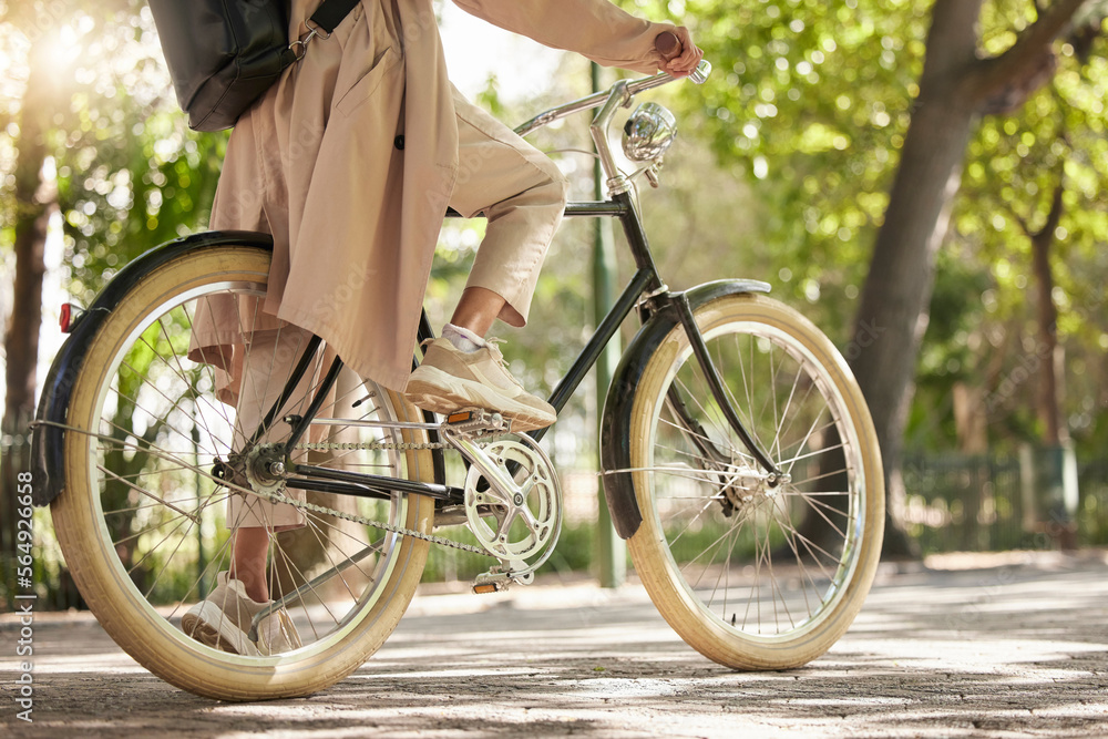 Bicycle, closeup and feet of casual cyclist travel on a bike in a park outdoors in nature for a ride or commuting. Exercise, wellness and lifestyle student cycling as sustainable transport - obrazy, fototapety, plakaty 