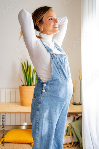 Healthy pregnant in denim overall at home photo