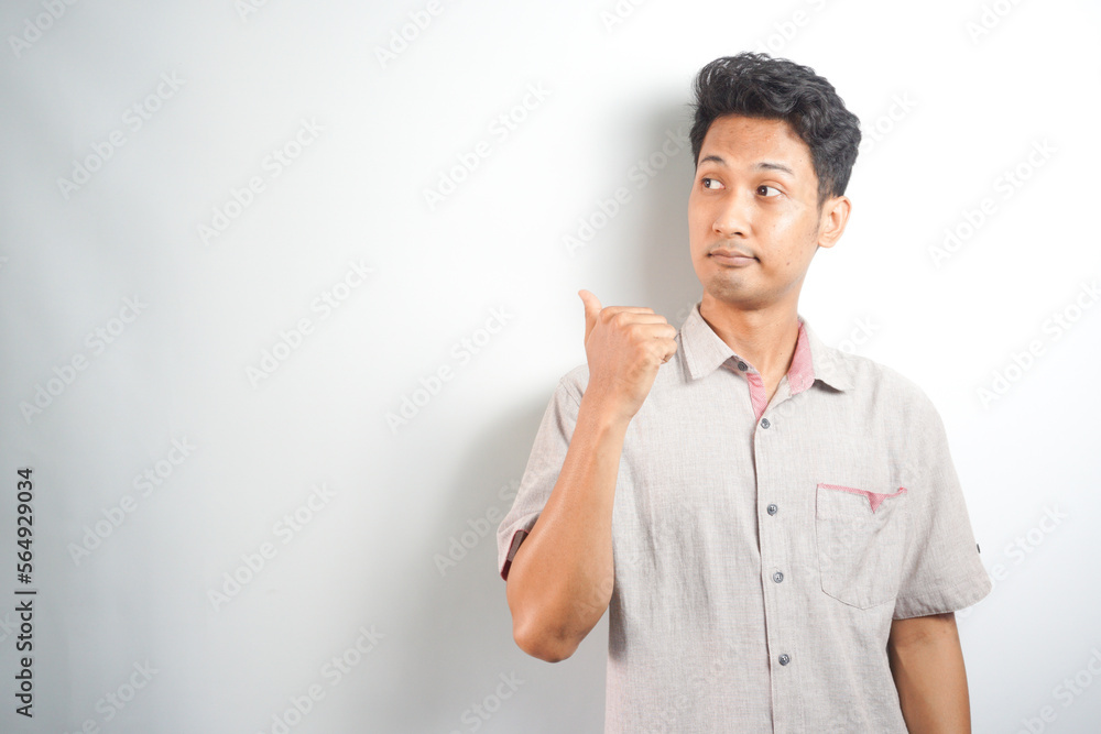 Young handsome man over isolated background pointing to the side to present a product Young handsome man over isolated background pointing to the side to present a product