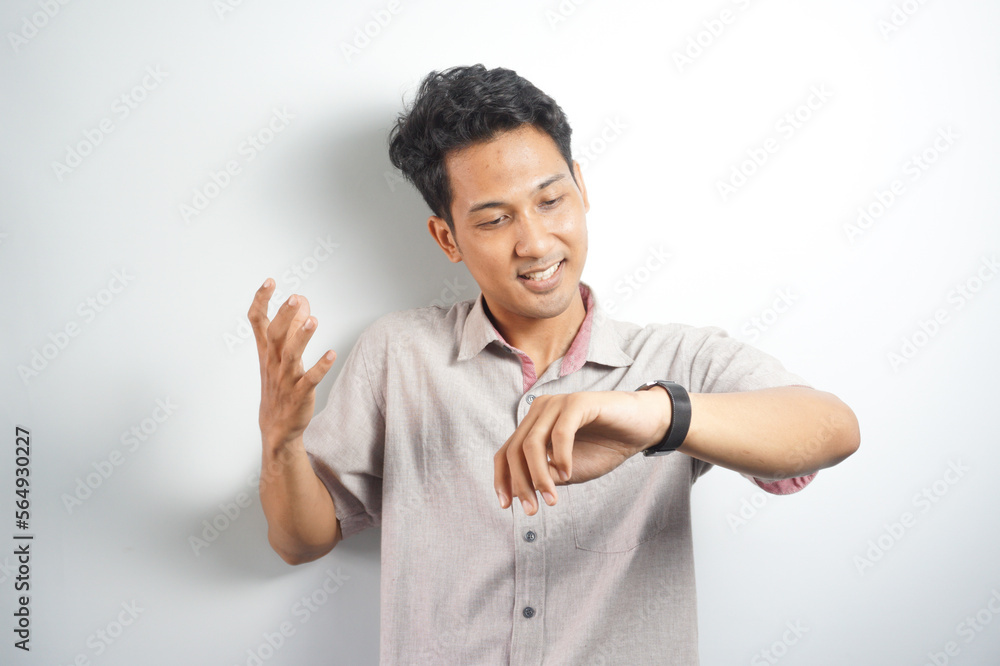 Happy and surprised Asian man who is looking at his watch. Shocked asian man in casual looking at watch Happy and surprised Asian man who is looking at his watch. Shocked asian man in casual looking at watch