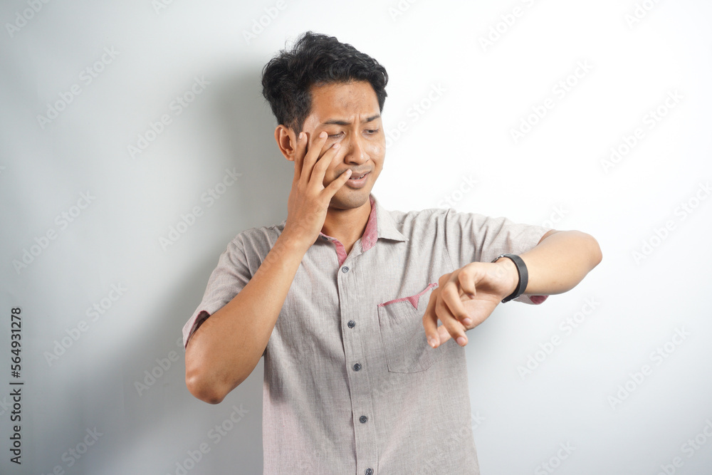 Shocked asian man in casual looking at watch Shocked asian man in casual looking at watch