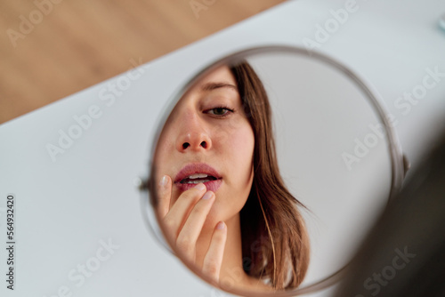 Woman applying moisturizing lip gloss