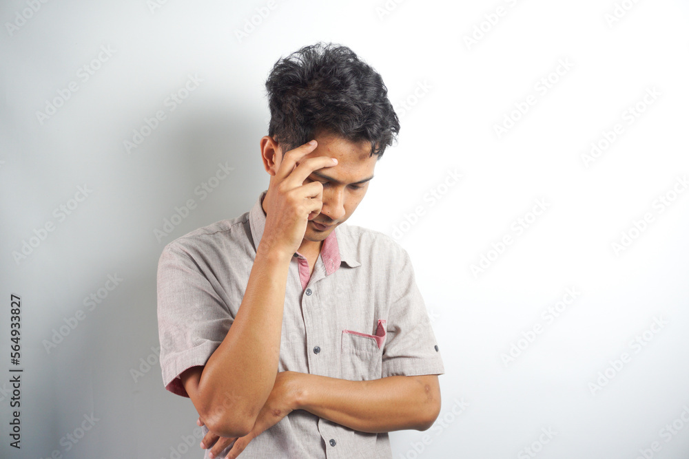 Horizontal photo of good-looking asian man pictured isolated on white background showing how much his head hurts, experiencing pain, looking miserable and exhausted Horizontal photo of good-looking asian man pictured isolated on white background showing how much his head hurts, experiencing pain, looking miserable and exhausted
