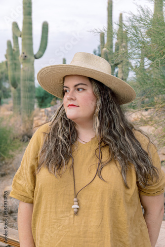 Plus size female in yellow dress exploring desert photo