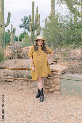 Plus size female in yellow dress exploring desert photo