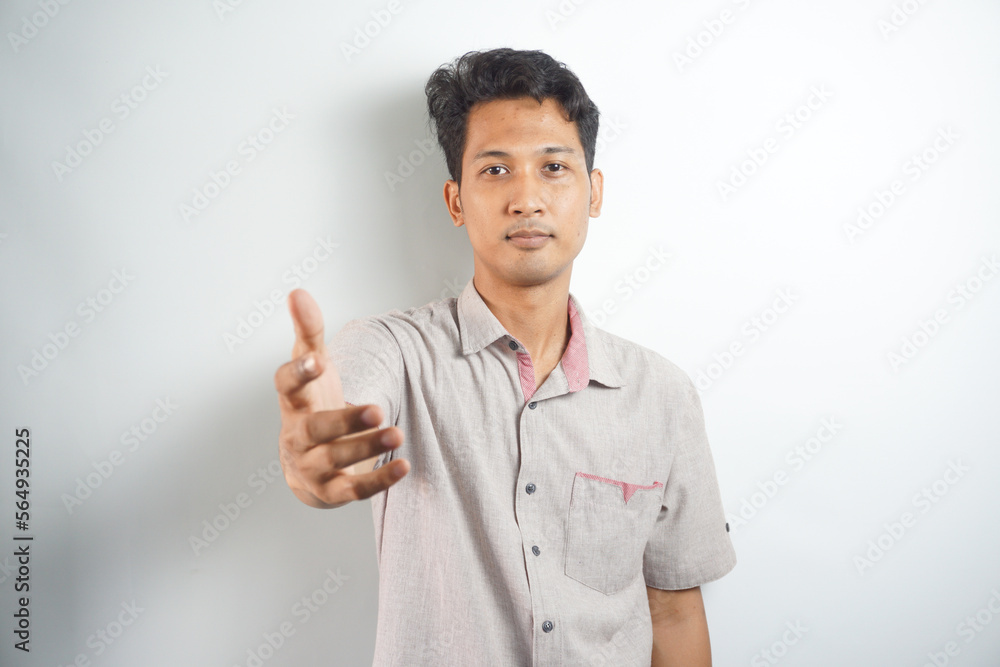 Confident businessman extending hand for handshake, greeting business partner and smiling, standing over white background Confident businessman extending hand for handshake, greeting business partner and smiling, standing over white background